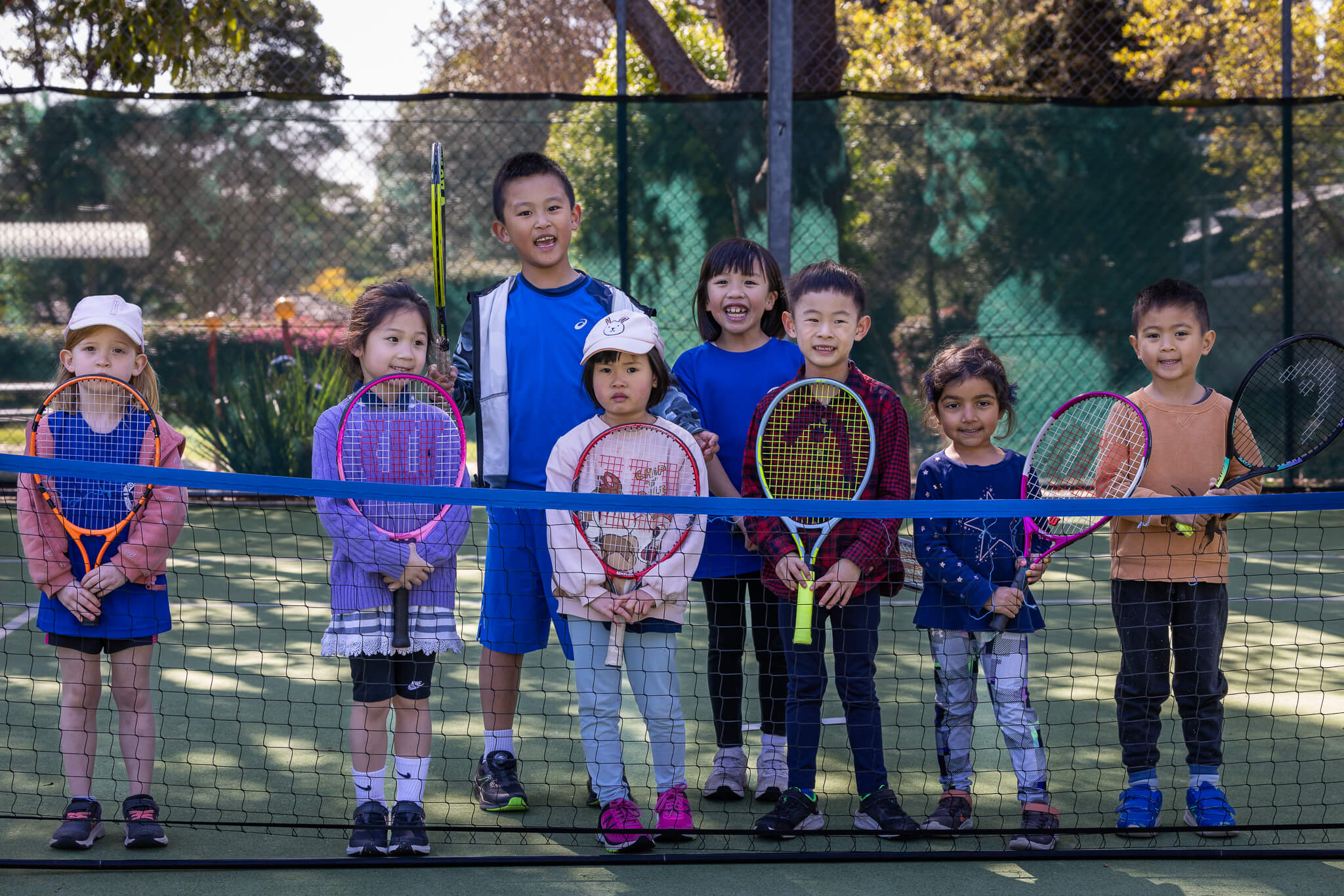 Junior players lining up during summer tennis camp