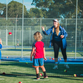 A woman coach having tennis session with the kids