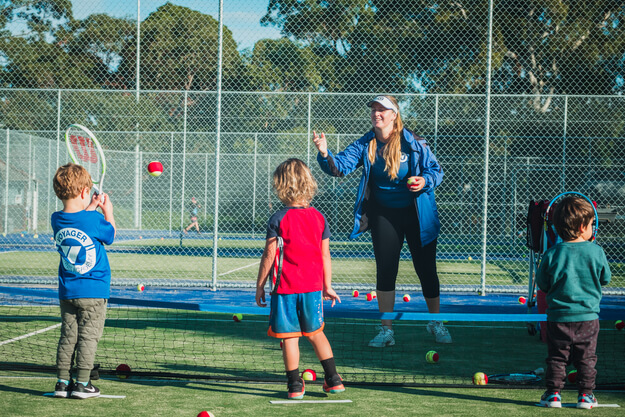 A woman coach having tennis session with the kids