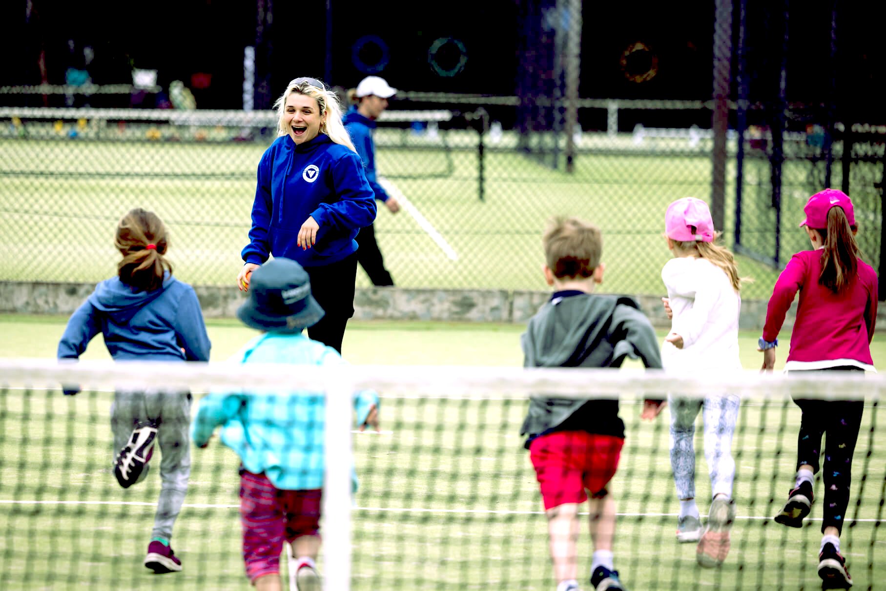 A woman tennis coach having fun with the kids