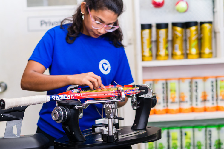 A woman doing tennis racket restringing